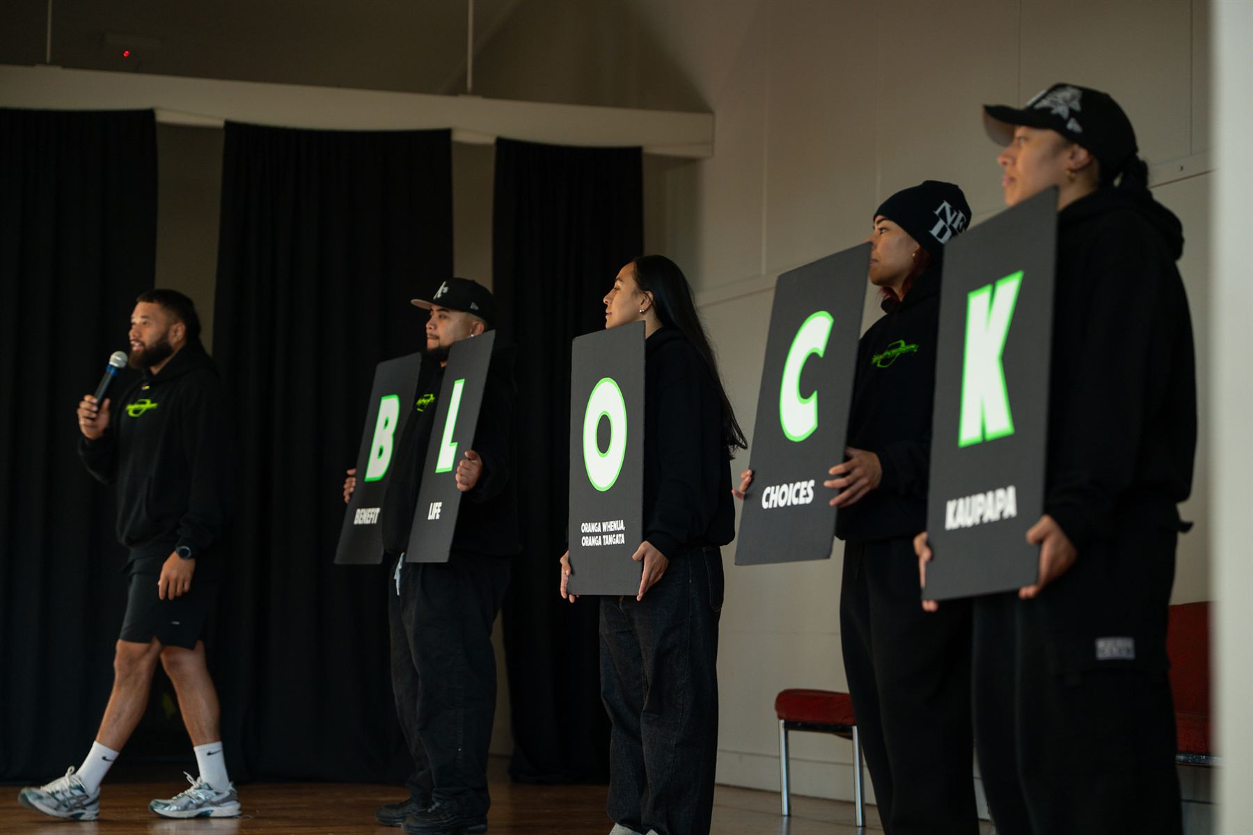 The BlockTober Crew on stage holding the five B.L.O.C.K cards while Montel Tivoli presents.