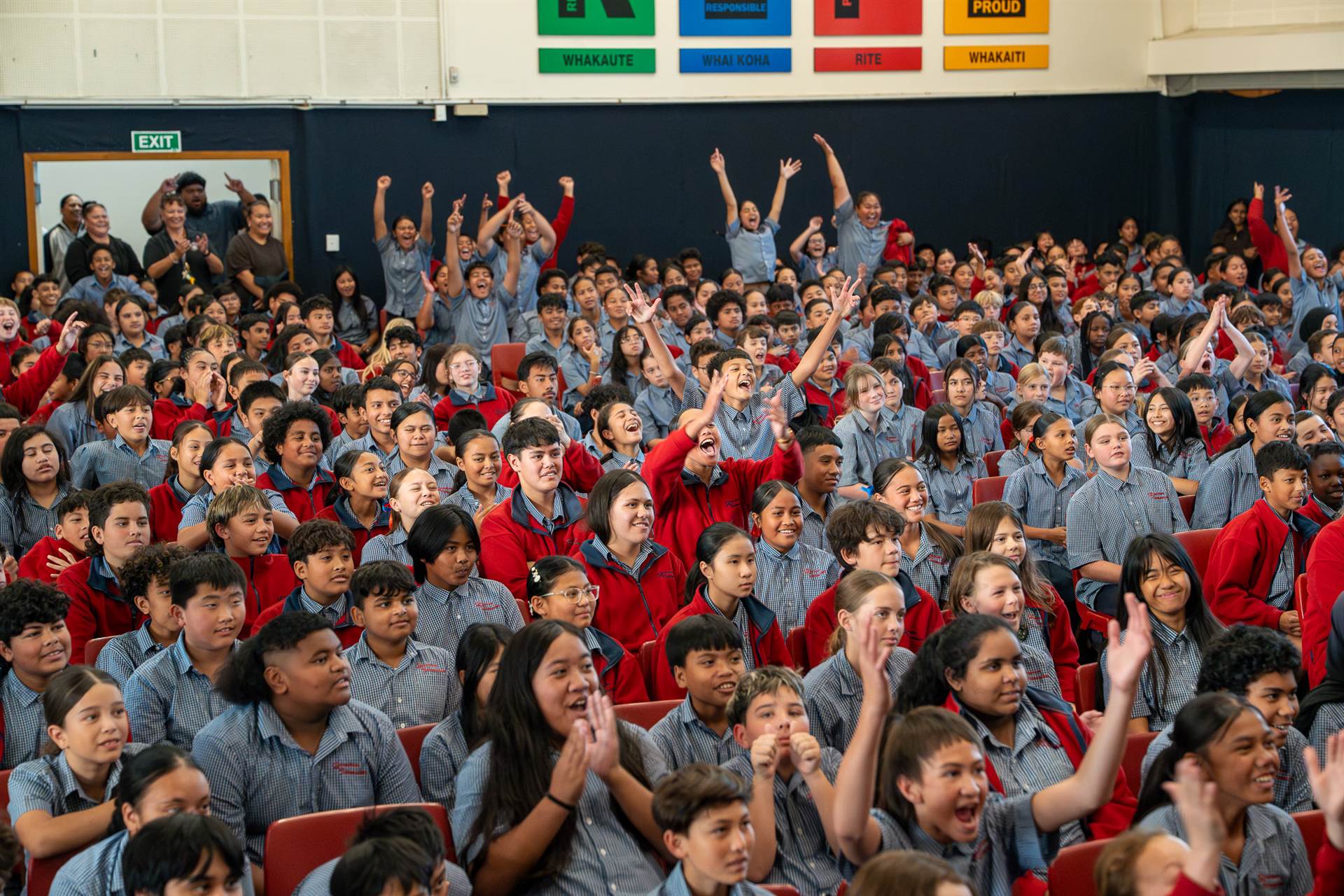 A school hall full of students with their arms up during a BlockTober session.